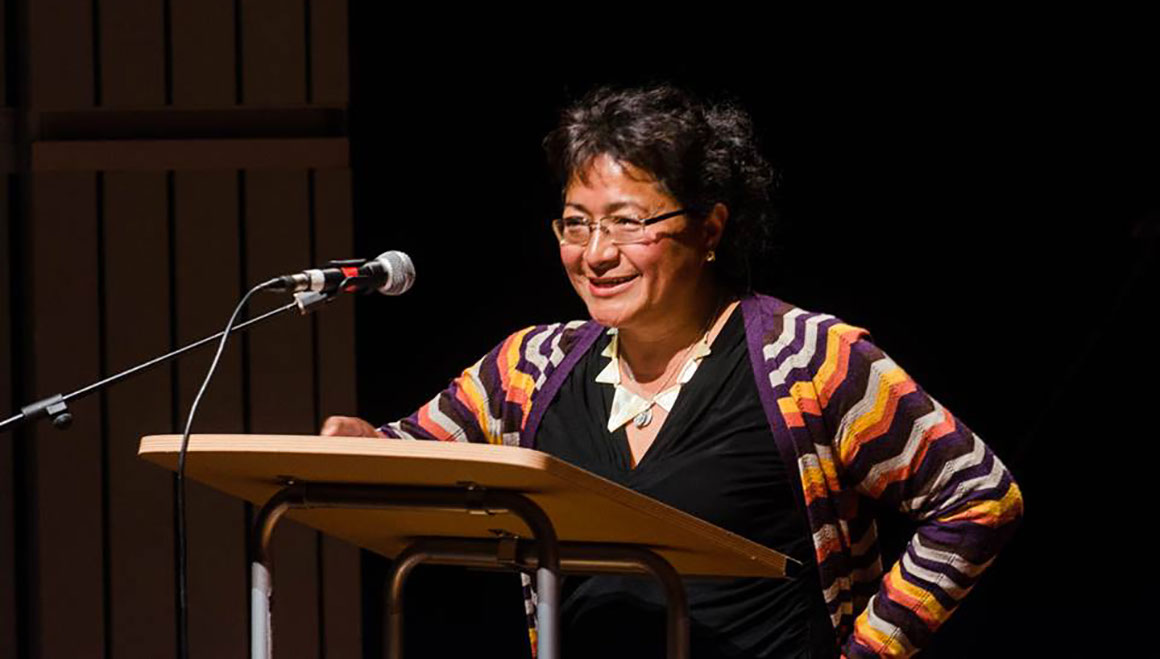 Mena Antonio speaking at lectern